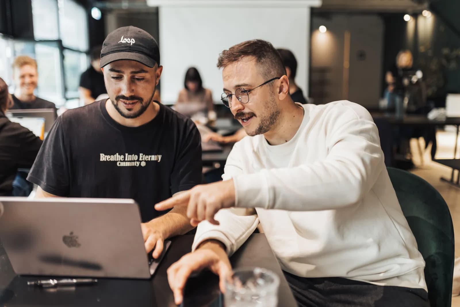 Person mit Headset vor Laptop und offenen Bewerbungsunterlagen